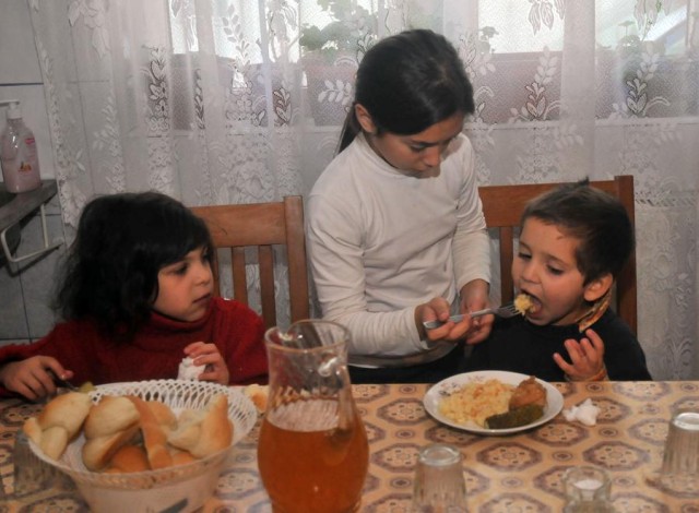 Intrajutorare frateasca la servitul mesei."./ Foto Liviu Maftei